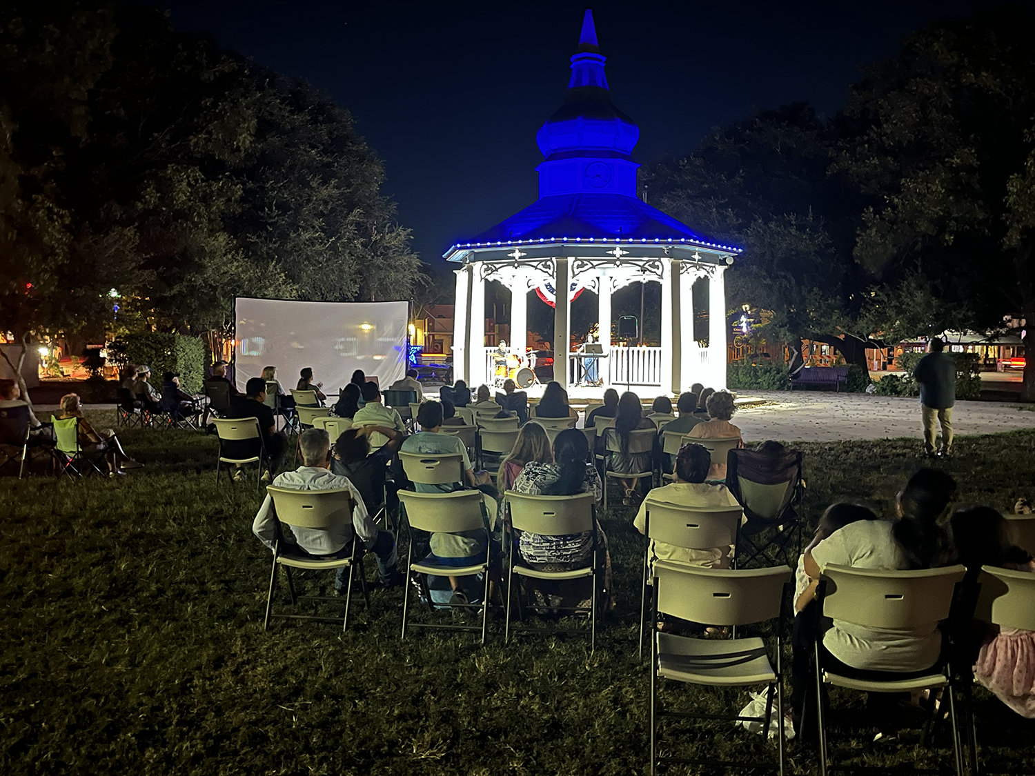 In the blue glow of the gazebo's lighting, we raise our voices