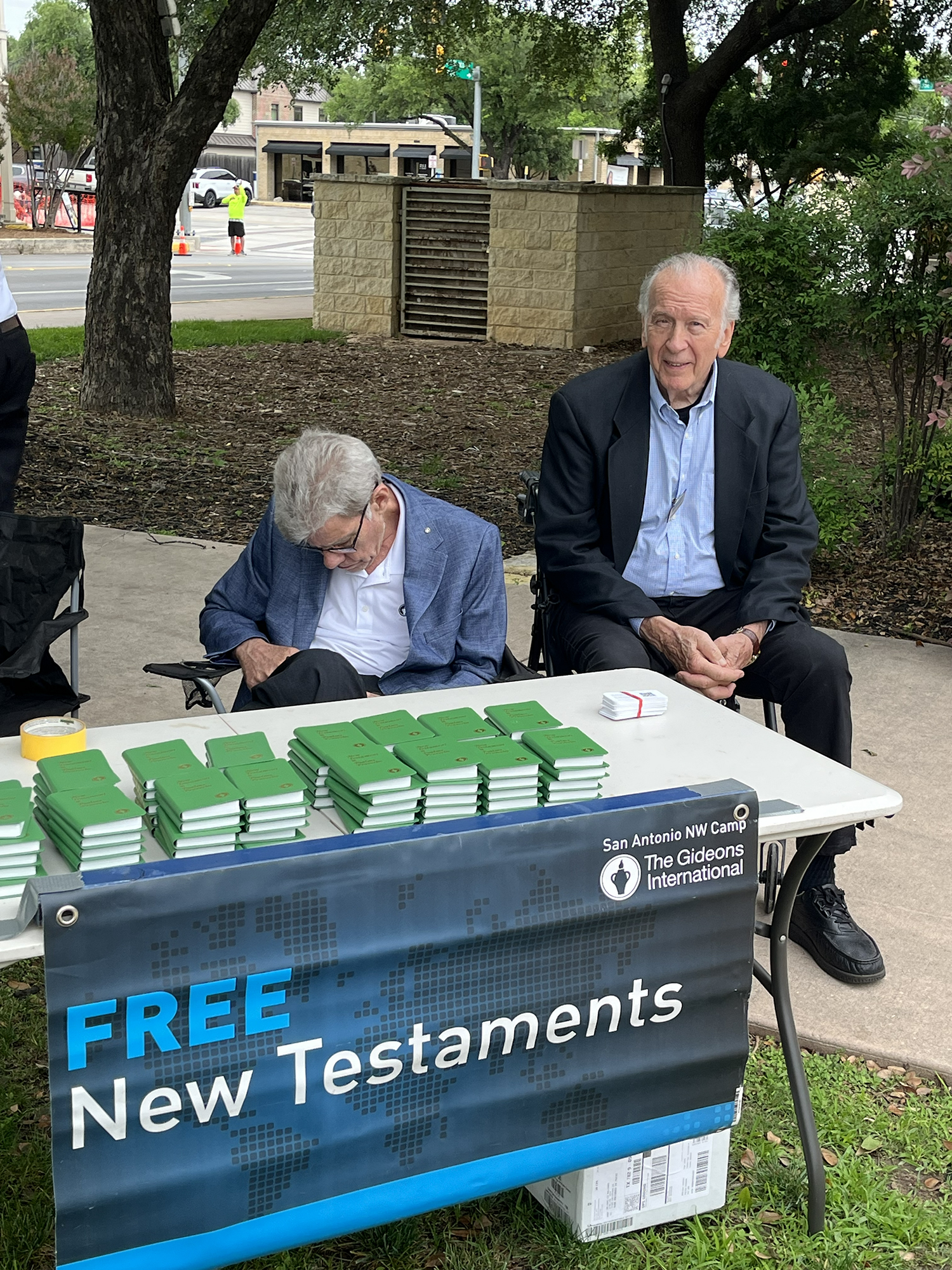 Gideons (Dan Spain and Henry Flick) staff the table to hand out New Testaments