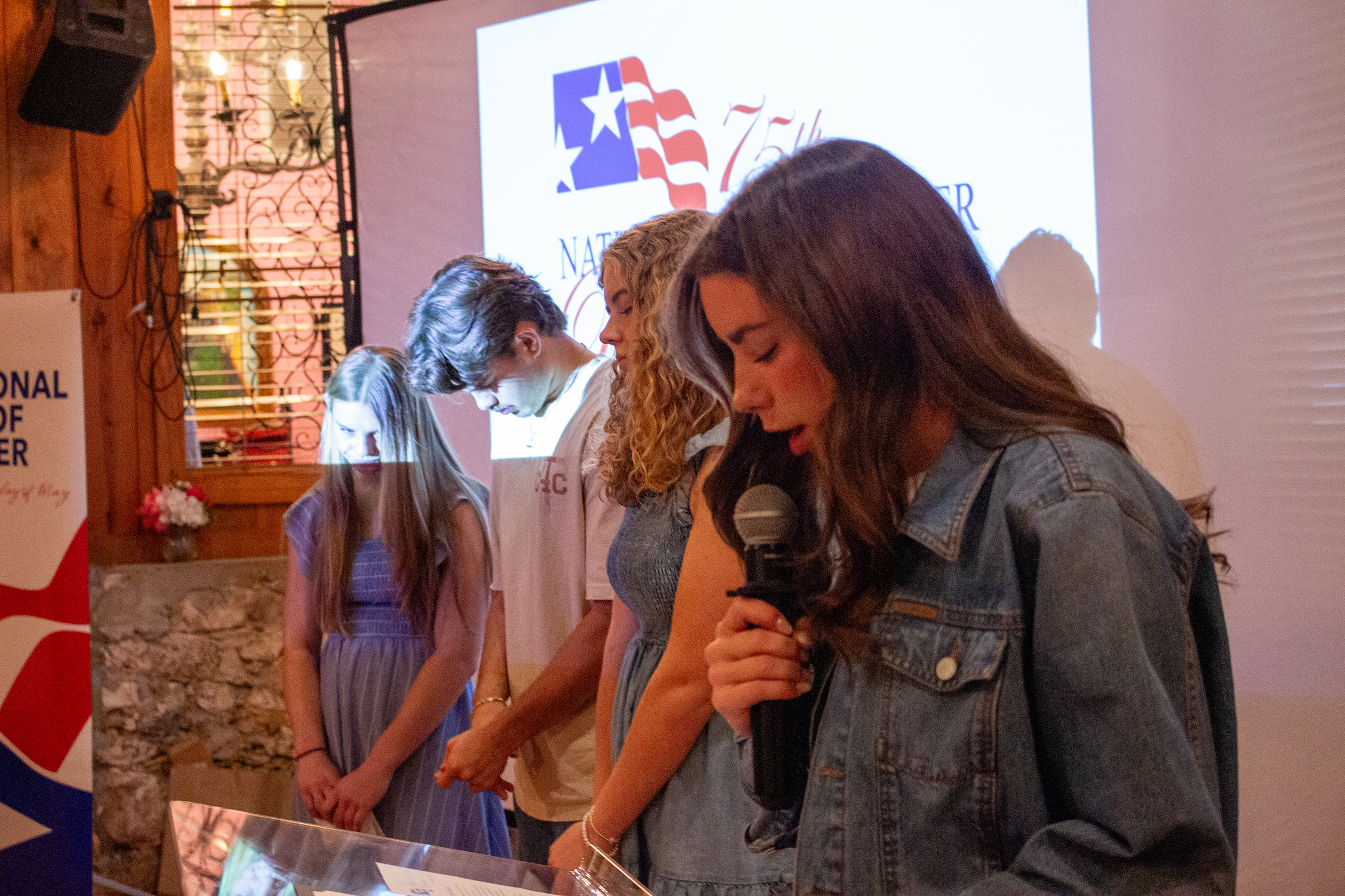 Young leaders Abigail Williams, Tristan Onweller, Molleigh Head, and Marilyn Curd pray for youth